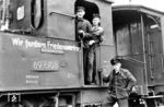 Lokführer Karl Rutz, Lokheizer Heinz Rahn und Zugschaffner Fritz Schramm präsentieren sich im Bahnhof Päwesin (vormals Westhavelländische Kreisbahnen) dem Fotografen. Die Parole an der Lok ging auf eine Initiative der SED vom Herbst/Winter 1951 zurück, wo sie unter dem Schlagwort „Deutsche an einen Tisch“ zu deutsch-deutschen Verhandlungen über freie Wahlen aufrief. Aus geostrategischen Gründen bemühte sich die Sowjetunion darum, die Westintegration der Bundesrepublik zu verhindern. Am 10. März 1952 nahm die Sowjetunion den Ruf der DDR nach einem Friedensvertrag auf, indem sie den Regierungen der USA, Großbritanniens und Frankreichs eine Note übergab, in der die Schaffung eines neutralen Gesamtdeutschlands vorgeschlagen wurde. Die Westmächte gingen mit Billigung der Bundesregierung nicht auf Stalins Angebot ein, was damals teilweise als "verpasste Chance" gesehen wurde. Heute sind sich die Historiker allerdings einig, dass die Stalin-Note keine wirkliche Chance zu einer Wiedervereinigung unter freiheitlich-demokratischen Vorzeichen geboten hätte. (22.05.1952) <i>Foto: Dr. med. Hans Gärtner (Slg. Armin Gärtner)</i>