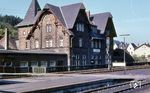 Der Bahnhof Jünkerath liegt an der Eifelstrecke von Köln nach Trier. Seine Bedeutung nahm Anfang des 20. Jahrhunderts mit dem Bau der Mittleren Ahrtalbahn nach Dümpelfeld und der Vennquerbahn über Losheim ins belgische Malmedy zu. Jünkerath entwickelte sich neben dem nahegelegenen Gerolsteiner Bahnhof zu einem wichtigen Knotenbahnhof in der Eifel. Sowohl das Güterzug- als auch das Personenzugaufkommen wuchs rapide an, weshalb der Bahnhof Jünkerath ständig erweitert wurde. Der Betrieb wurde über vier Stellwerke abgewickelt und es gab ein eigenes Bahnbetriebswerk. Das aus rotem Bruchstein gebaute Bahnhofsgebäude steht seit 1978 unter Denkmalschutz. Es fügt sich in den einheitlichen Stil der entlang der Eifelstrecke erbauten Bahnhofsgebäude ein. Die Bauten wurden von dem Geld, das Frankreich als Kriegsschuld nach dem Deutsch-Französischen Krieg 1870/71 an Deutschland zahlen musste, finanziert. (08.1964) <i>Foto: Karl-Ernst Maedel</i>